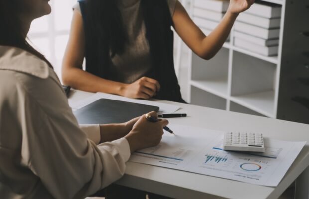 Two people discussing documents at a table