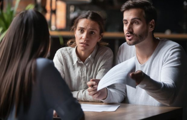 Three people discussing documents at a table.